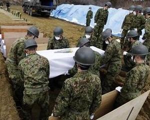 JAPONIA: Cele 9.199 de morti confirmate se asteapta sa depaseasca 20.000. Japonezii isi ingroapa rudele in uriase gropi comune
